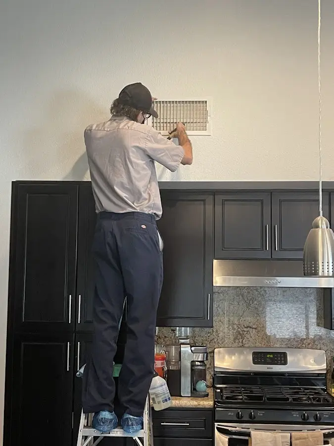 Technician inspecting an air vent during HVAC service in Coraopolis